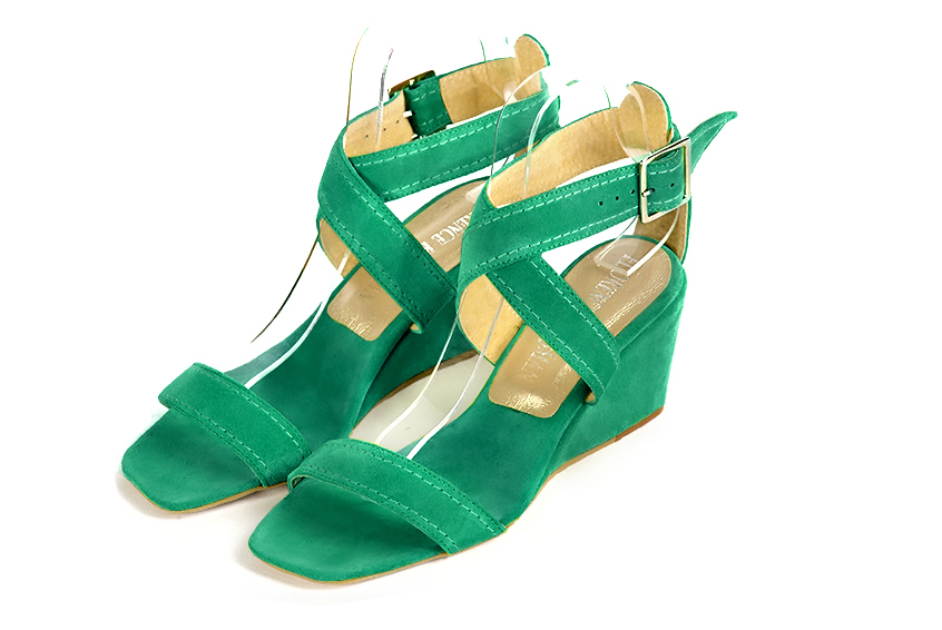 Emerald green elegant sandals with cross straps across the instep, fully open. Square toe. Medium wedge heels.